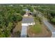 Aerial view of a well-maintained home with lush landscaping, a paved driveway, and mature trees at 3376 Dunbar St, Port Charlotte, FL 33948