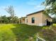 Home exterior featuring a covered back patio, large windows, lush green lawn, and mature trees at 3376 Dunbar St, Port Charlotte, FL 33948