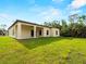 The home features a covered back porch, large windows, and a spacious green lawn at 3376 Dunbar St, Port Charlotte, FL 33948
