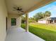 Back porch with ceiling fan and view of grassy yard with palm trees at 3376 Dunbar St, Port Charlotte, FL 33948