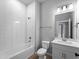 Modern bathroom with white subway tile, tub and shower combo, toilet, and vanity with white countertop at 3376 Dunbar St, Port Charlotte, FL 33948