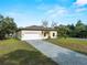Charming single-story home with a paved driveway, attached two-car garage, and manicured lawn under a bright blue sky at 3376 Dunbar St, Port Charlotte, FL 33948