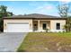 Inviting single-story home showcasing a neutral color scheme, attached garage, and well-manicured front yard at 3376 Dunbar St, Port Charlotte, FL 33948