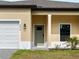 Close-up of a home's front entrance with a neutral green door, modern lighting, and a well-kept lawn at 3376 Dunbar St, Port Charlotte, FL 33948