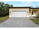 Attached two-car garage with carriage lamps and brick paver driveway for this home at 3376 Dunbar St, Port Charlotte, FL 33948