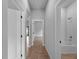Hallway featuring modern tile flooring, white doors, and neutral paint leading to the bath and bedroom at 3376 Dunbar St, Port Charlotte, FL 33948