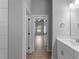 Hallway view leading to the bathroom, highlighting the wood-look tile flooring and modern design at 3376 Dunbar St, Port Charlotte, FL 33948