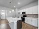 Modern kitchen with white cabinets, stainless steel appliances, granite countertops and an island with a sink at 3376 Dunbar St, Port Charlotte, FL 33948