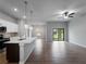 Open concept living room with tile floors, stylish pendant lighting, a ceiling fan, and sliding glass doors at 3376 Dunbar St, Port Charlotte, FL 33948