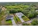 Aerial view of a modern home with a separate garage and a paved driveway in a lush area at 4081 Felhorn St, Port Charlotte, FL 33948