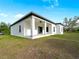 Back exterior view of home showcasing a covered patio, windows, and the surrounding yard at 4081 Felhorn St, Port Charlotte, FL 33948
