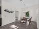 Bright dining room featuring modern light fixture, wood-look floors, and decorative fish art at 4081 Felhorn St, Port Charlotte, FL 33948
