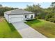 A modern home boasts a manicured lawn, elegant driveway, and serene landscaping at 4081 Felhorn St, Port Charlotte, FL 33948