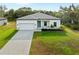 Charming single-story home with a brick driveway, attached garage, manicured lawn, and welcoming blue front door at 4081 Felhorn St, Port Charlotte, FL 33948
