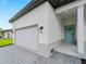 A modern single-story home featuring a bright turquoise front door and a convenient attached two-car garage at 4081 Felhorn St, Port Charlotte, FL 33948