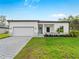 Beautiful single-story home with a well-manicured lawn, blue door, and paved driveway for curb appeal at 4081 Felhorn St, Port Charlotte, FL 33948