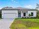 Charming single-Gathering home with a well-manicured lawn and a two-car garage, with a light blue door at 4081 Felhorn St, Port Charlotte, FL 33948