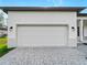 Attached two-car garage with paved driveway and exterior lighting, adding convenience and curb appeal at 4081 Felhorn St, Port Charlotte, FL 33948