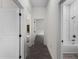 Hallway features modern wood-look tile flooring leading to the bathroom, adding warmth and style at 4081 Felhorn St, Port Charlotte, FL 33948