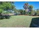 Large grassy backyard with canal access, mature trees, and a fenced area at 5731 Oakview Ln, Punta Gorda, FL 33950