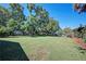 Large grassy backyard with mature trees and a fenced area at 5731 Oakview Ln, Punta Gorda, FL 33950
