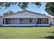 Rear view of a single-story house with a screened porch and lush lawn at 5731 Oakview Ln, Punta Gorda, FL 33950