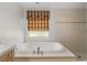 Relaxing bathroom with a jetted tub and window at 15 Windward Pl, Placida, FL 33946