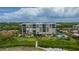 Aerial view of condo building, pool, and tennis courts at 2675 Gulf Of Mexico Dr # 204, Longboat Key, FL 34228