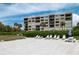 Beachfront view of condo building with lounge chairs and picnic tables at 2675 Gulf Of Mexico Dr # 204, Longboat Key, FL 34228