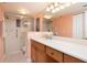 Updated bathroom with double vanity, walk-in shower, and large mirror at 2675 Gulf Of Mexico Dr # 204, Longboat Key, FL 34228