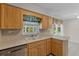 Bright kitchen featuring wood cabinetry, double basin sink, and stainless steel dishwasher at 1585 Harmony Dr, Port Charlotte, FL 33952