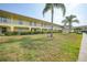 Two-story yellow building with balconies and lawn at 4000 Bal Harbor Blvd # 214, Punta Gorda, FL 33950