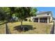 Fenced backyard with a large tree and screened patio at 10034 Winding River Rd, Punta Gorda, FL 33950