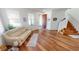 Living area with hardwood floors, beige couch, and staircase at 10034 Winding River Rd, Punta Gorda, FL 33950