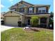 Two-story house with tan siding, brown shutters, and a landscaped yard at 10034 Winding River Rd, Punta Gorda, FL 33950