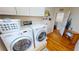 Clean laundry room with front-load washer and dryer, plus storage at 10034 Winding River Rd, Punta Gorda, FL 33950