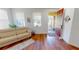 Living room with hardwood floors, beige couch, and access to the porch at 10034 Winding River Rd, Punta Gorda, FL 33950