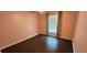 Simple bedroom with light pink walls and dark wood-look floors at 4530 Irdell Ter, North Port, FL 34288