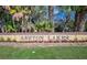 Ashton Lakes sign in front of landscaped entrance with mature palm trees and colorful flowering plants at 5685 Ashton Lake Dr # 2, Sarasota, FL 34231