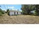 Spacious backyard featuring a single-story home with an enclosed porch and sparse landscaping at 18300 Troon Ave, Port Charlotte, FL 33948