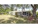 Relaxing backyard featuring a single-story home with screened porch and mature trees at 18300 Troon Ave, Port Charlotte, FL 33948