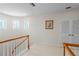 Upper landing with white walls, wood railing, and windows at 1060 San Mateo Dr, Punta Gorda, FL 33950
