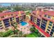 Aerial view showing a condo community with a pool and surrounding buildings at 8750 Midnight Pass Rd # 202, Sarasota, FL 34242