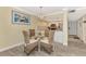 Charming dining area with glass table, wicker chairs, and a modern chandelier at 8750 Midnight Pass Rd # 202, Sarasota, FL 34242