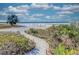 Sandy walkway to Siesta Key Beach with lush vegetation on either side at 8750 Midnight Pass Rd # 202, Sarasota, FL 34242