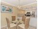 Cozy dining area with glass table, wicker chairs, and a modern chandelier at 8750 Midnight Pass Rd # 202, Sarasota, FL 34242