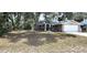 Spacious front yard with a large tree shading the house, complemented by a well-maintained lawn and driveway at 5367 Vantage St, North Port, FL 34288