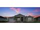 Two-story house with a gray exterior, and a sunset in the background at 15512 Greenwood Ave, Port Charlotte, FL 33981