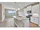Modern kitchen with white cabinets, granite island, and stainless steel appliances at 15512 Greenwood Ave, Port Charlotte, FL 33981