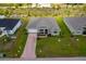 Aerial view of a house with a paved driveway and grassy lawn at 15512 Greenwood Ave, Port Charlotte, FL 33981